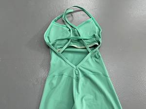 Detail des minzgrünen Yoga Overalls mit rückenfreiem Design und Kreuzgurten