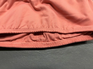 Close-up of coral pink yoga bra featuring double-needle stitching and elastic ribbed hem