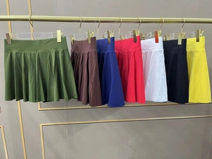 Jupes de tennis plissées taille haute multicolores exposées sur des cintres en sept couleurs