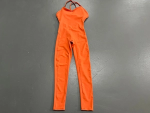 Details der überkreuzten Träger und des rückenfreien Designs beim orangen Yoga-Jumpsuit