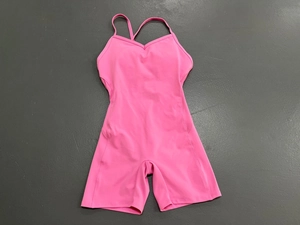 Dettaglio tuta da yoga rosa acceso con spalline sottili e scollo a V per fitness training