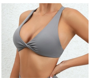 Close-up of gray high-elastic yoga bra featuring elegant front cross twist knot detail