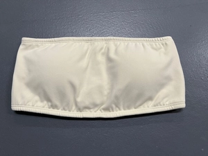 Detail of off-white strapless yoga sports bra with elastic edges and ribbed texture