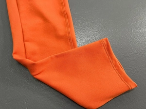 Detailaufnahme des orangefarbenen Yoga-Einteilers mit hochwertiger Doppelnaht-Verarbeitung