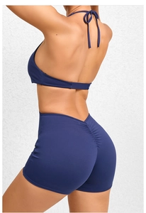 Detail view of ruched back lift on navy yoga bodysuit showing compression fabric