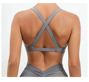 Detail view of dark grey criss-cross back sports bra and high-waisted yoga leggings