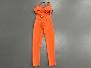 Überkreuzte Träger am rückenfreien orangefarbenen Yoga-Jumpsuit aus Stretch-Stoff