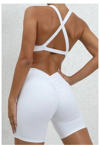 Rear view of white yoga set featuring criss-cross back bra and scrunch butt gym shorts