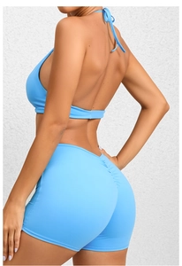 Detail of light blue yoga jumpsuit with ruched shorts and cross strap back design