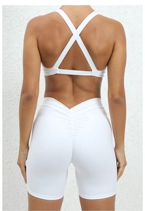 Detail of white cross back sports bra and scrunch butt yoga shorts for women fitness