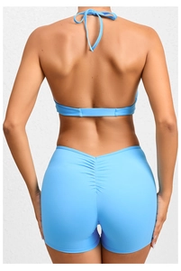 Detail view of sky blue backless yoga romper with halter neck and ruched butt-lift feature