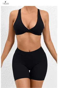 Detail of black two-piece yoga set featuring twist-front sports bra and high-waisted shorts