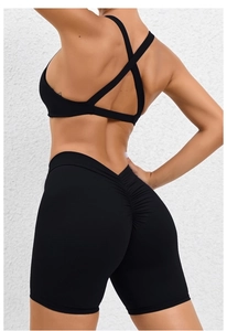 Detail view of black yoga set showing cross-back sports bra and scrunch butt gym shorts