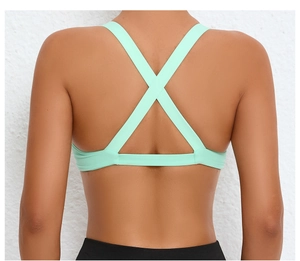 Detail of the mint green sports bra featuring an elegant cross-back strap design