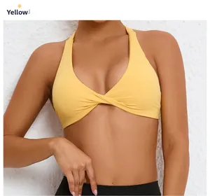 Detail of yellow halter sports bra featuring a twist front design and breathable fabric