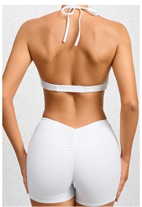 Detail of white two-piece yoga set featuring halter top and ruched high-waisted shorts