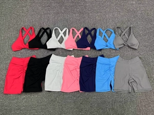 Flat lay of yoga sets in seven colors featuring cross-back bras and ruched sports shorts