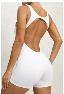 Detailed back view of white one-piece yoga romper featuring a deep U-shaped open back design