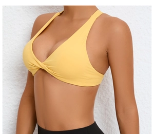 Detail of yellow sports bra featuring front twist design and V-neckline elastic fabric