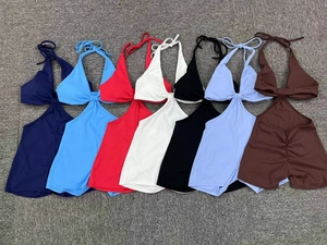 Detailed flat lay of seven-color cutout yoga jumpsuits featuring halter neck and knot detail