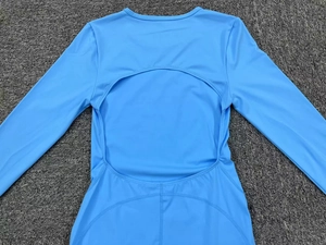 Detail view of sky blue long sleeve yoga bodysuit with back circular cutout design