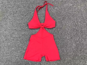 Detailed view of the red cutout athletic yoga bodysuit showing halter neck and knot detail