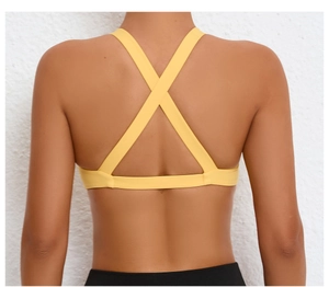 Detail of yellow sports bra featuring X-back cross straps and moisture-wicking fabric