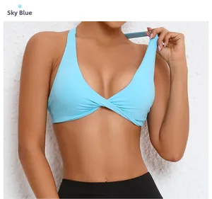 Detail of sky blue sports bra featuring twist-front design and glossy elastic fabric