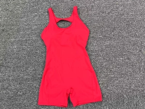 Flat lay detail of red one-piece yoga bodysuit featuring hollow back and athletic cut