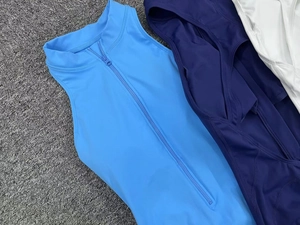 Close-up of seamless yoga jumpsuits with half-zip collars in light blue and navy tones