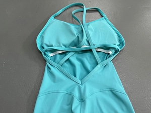Detail der überkreuzten Rückenträger und V-förmigen Taillennaht am türkisen Jumpsuit