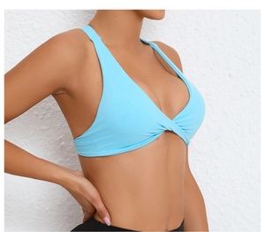 Detail of light blue sports bra with front knot design and wide straps for fitness