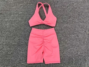 Detail of neon pink yoga set showing V-neck cross back bra and ruched butt lift shorts