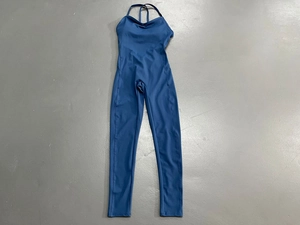 Flachbild-Ansicht eines dunkelblauen rückenfreien Yoga-Jumpsuits auf grauem Boden