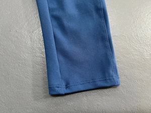 Detailansicht der doppelgenähten Saumkante der blauen Yoga-Jumpsuit-Leggings