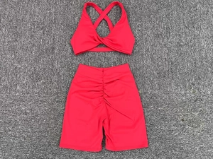 Flat lay of red yoga set showing cross back sports bra and scrunch butt gym shorts
