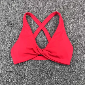 Detail of red sports bra showing front twist knot and criss-cross back straps design