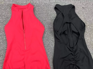 Detail of red front zipper neckline and black yoga jumpsuit with ruched back design