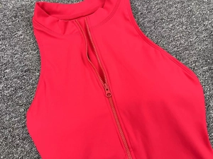 Close-up of red high-stretch yoga bodysuit featuring a front zipper and mock neck design