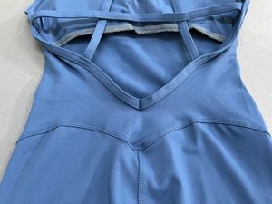 Detail der Kreuzgurte und V-Nähte an einem dunkelblauen Yoga-Jumpsuit