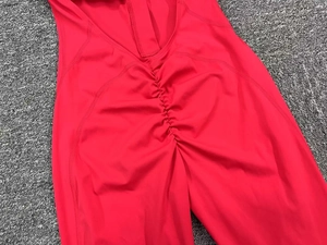 Close-up of rose red yoga jumpsuit featuring scrunch butt design and elastic knit fabric