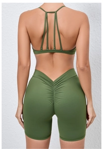 Detail view of olive green yoga set featuring multi-strap back and ruched lifting shorts
