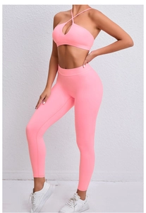 Détail d'un ensemble de yoga rose avec brassière croisée dans le dos et legging taille haute