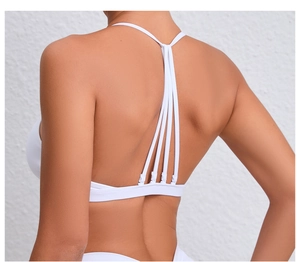 Détail du soutien-gorge de sport blanc montrant le design élégant à brides multiples au dos