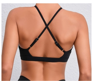 Détail des bretelles croisées au dos d'un soutien-gorge de sport noir respirant