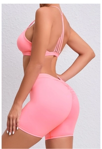 Detail of pink yoga set featuring thin criss-cross back straps and scrunch butt lifting shorts