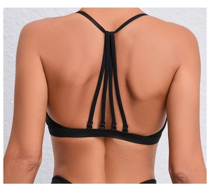Détail d'un soutien-gorge de yoga noir avec dos croisé multi-bretelles et tissu élastique