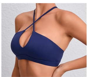 Détail d'un soutien-gorge de sport bleu foncé avec licou croisé et découpe en goutte