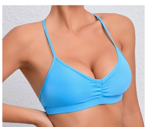 Détail de brassière sport bleu clair avec col en V et fronces centrales de maintien