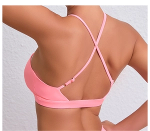 Détail du soutien-gorge de sport rose avec sangles croisées et boucles métalliques